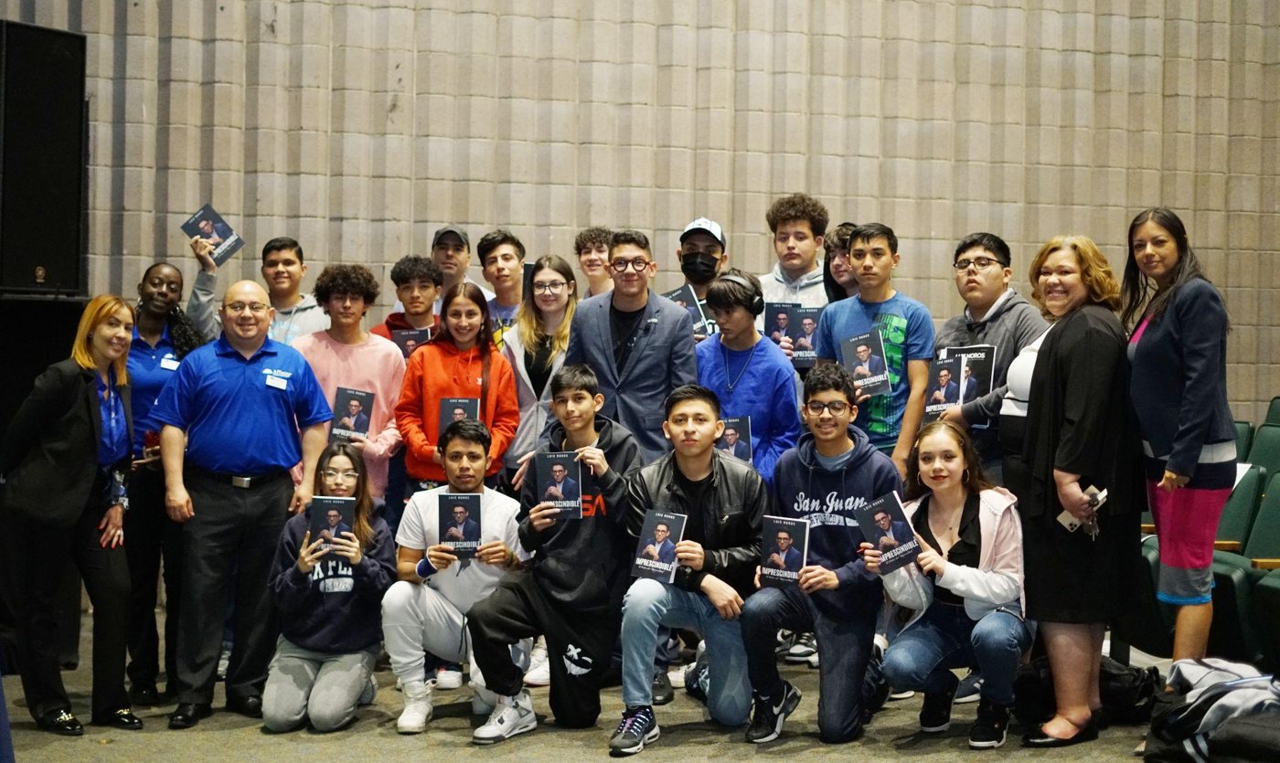 Luis Moros con un grupo de estudiantes que sostienen su libro